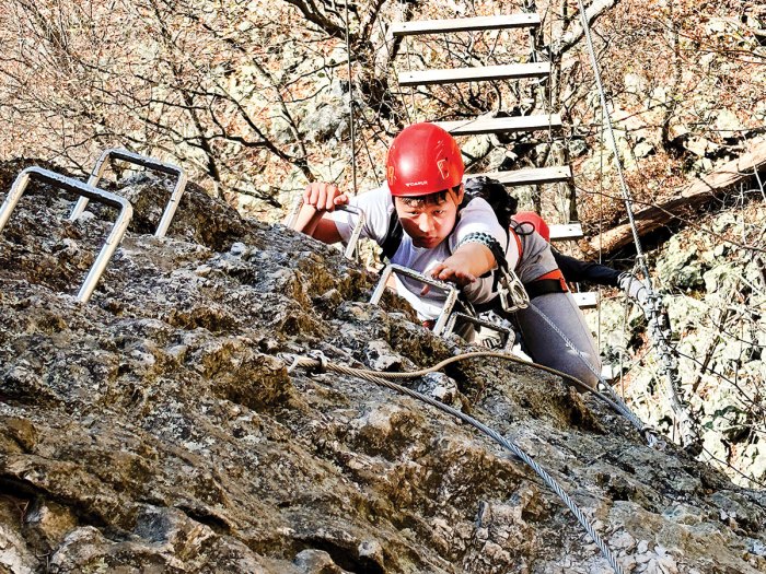 Reaching for an iron rung on a via ferrata in west virginia